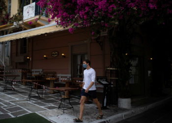 A man wearing a protective face mask makes his way next to a closed restaurant in Plaka district, amid the coronavirus disease (COVID-19) pandemic, in Athens, Greece, November 3, 2020. REUTERS/Alkis Konstantinidis
